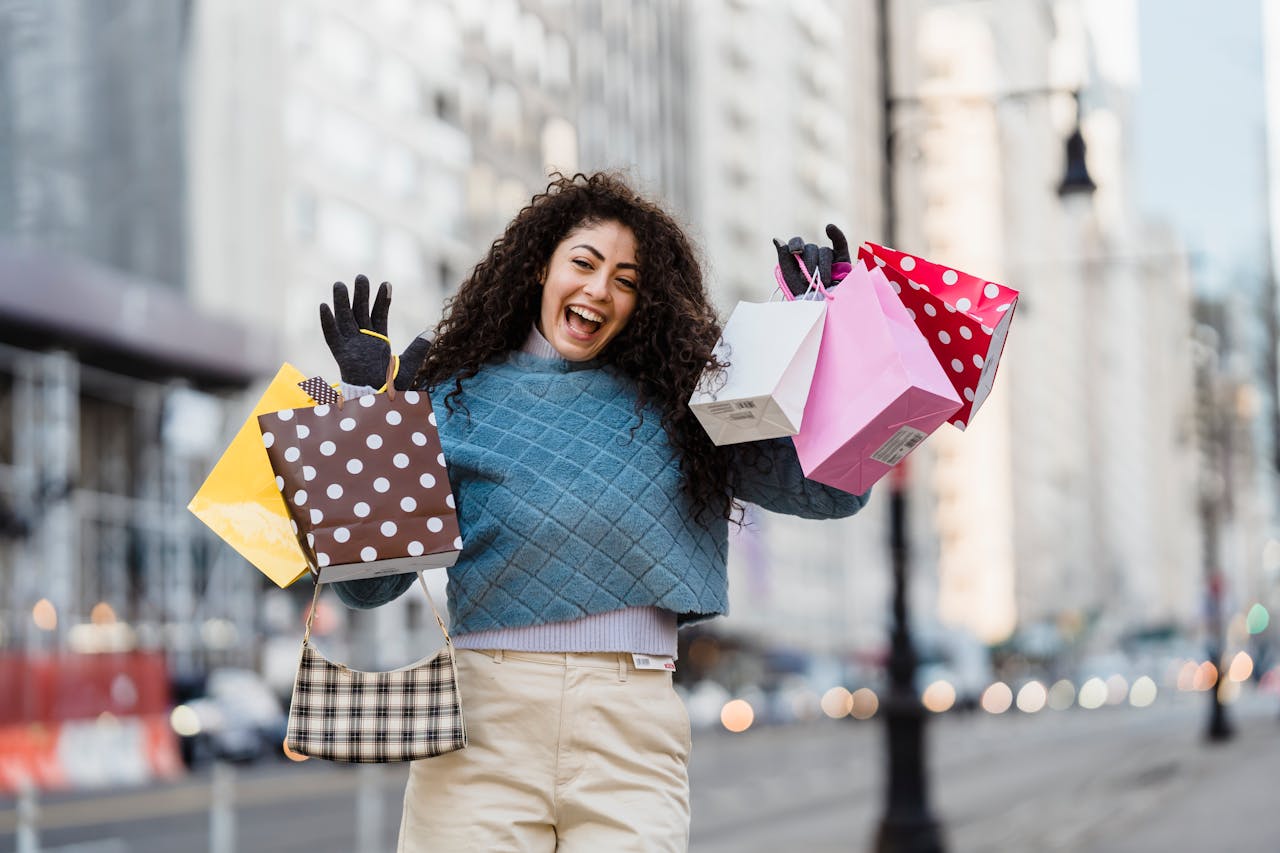 Happy woman with shopping bags, smiling in an urban setting. Vibrant city life captured in a candid moment.